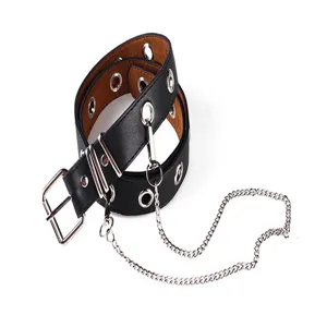 Detail of black punk leather belt with silver grommets and decorative chain accessory.