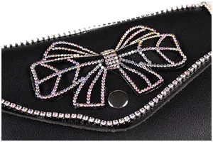 Macro view of the iridescent rhinestone bow on a black leather waist bag.