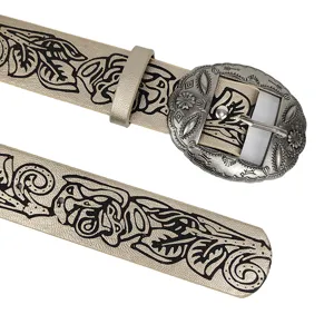 Detail view of western style belt with black floral print and engraved silver buckle