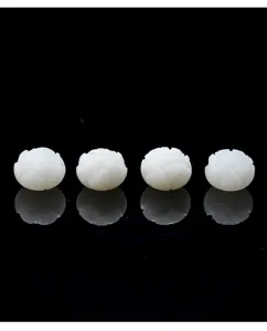Detailed macro view of white carved lotus beads with delicate flower petal details