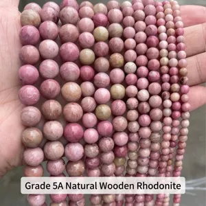 Primo piano di perle in pietra naturale rosa di varie dimensioni per fai-da-te