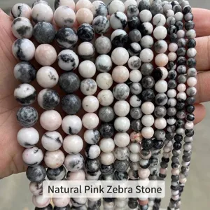 Primo piano di perle naturali in diaspro zebra rosa in varie dimensioni per gioielli.