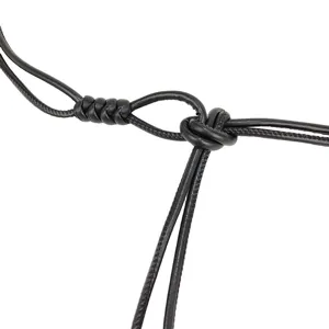 Detailed macro view of an elegant black thin leather cord belt showing its knotted design