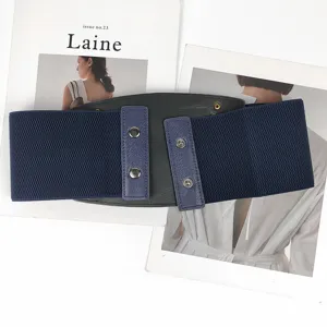 Detailed view of a wide navy blue elastic waist belt with metal snap button closure