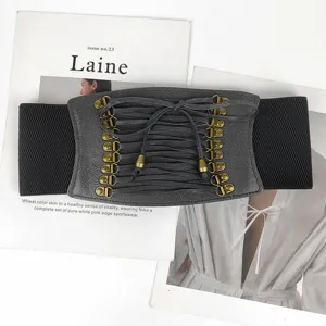Detailed view of a wide black elastic corset belt with grey lace-up front and bronze hooks.