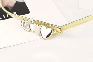 Detailed close-up of a gold elastic metal belt featuring a stylish multi-heart buckle design.
