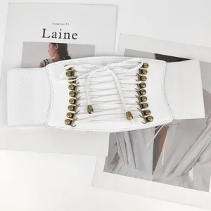 Detail view of white lace-up corset belt with bronze metal hooks and elastic band