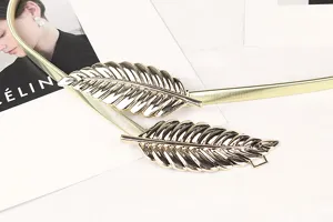 Detail of gold elastic metal belt with stylish leaf-shaped buckle decoration