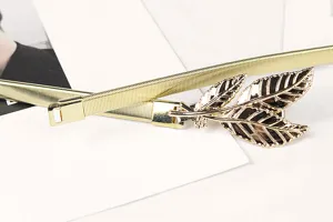 Close-up detail of the elegant gold leaf buckle on an elastic metal chain waist belt