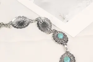 Detailed macro view of vintage silver metal chain belt featuring turquoise stone inlays