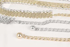 Close-up detail of stylish gold and silver metal chain belts featuring rhinestones