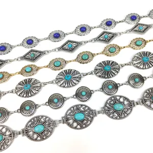 Detailed macro view of bohemian metal chain belts with turquoise and blue stone inlays