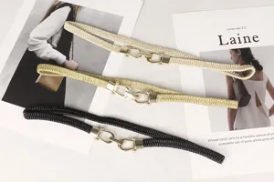 Primer plano de cinturones elásticos en crema, oro y negro con hebillas de metal