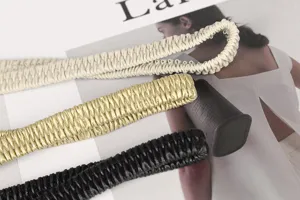 Primer plano detallado de tres cinturones elásticos trenzados en crema, oro y negro