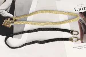 Detalle de cinturones elásticos en oro y negro con hebillas de metal de herradura