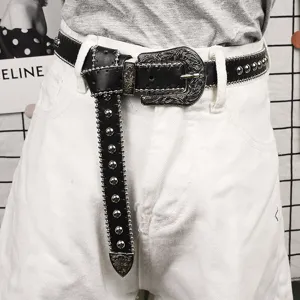 Detailaufnahme eines schwarzen Ledergürtels im Punk-Stil mit Nieten und Western-Schnalle