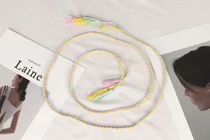 Detailed macro view of colorful braided waist rope belt with decorative tassels