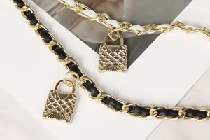 Detail view of golden lock pendant and woven leather metal chain belt for women