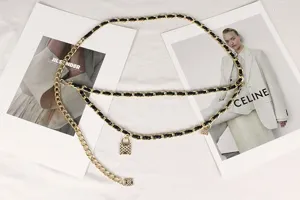 Detailed view of a double-layered gold chain belt with lock pendants and black weave
