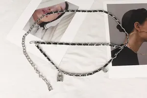 Detail view of a chic woven silver metal chain belt featuring textured padlock charms