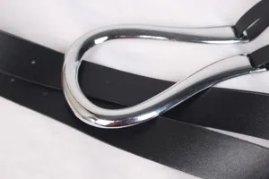 Gros plan détaillé de la boucle métallique solide en forme de U sur ceinture en cuir noir