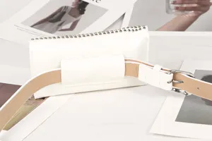 Close-up detail of the white punk-style studded waist bag with adjustable belt strap