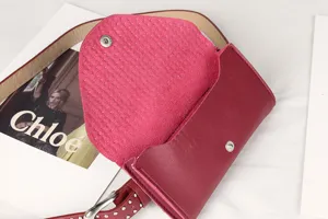 Close-up of magenta punk style rivet waist bag showing inner texture and snap button