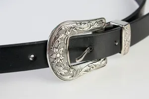 Dettaglio di una cintura nera vintage Y2K con fibbia in argento intagliato a mano.