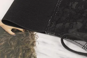 Close-up macro detail of black floral lace and ribbed elastic material on a corset belt