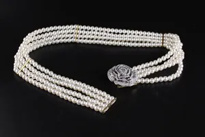 Detailed view of elegant four-row pearl belt with a shimmering rhinestone rose buckle