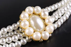Close-up of elegant four-row pearl belt with rhinestone flower buckle