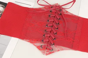 Detail of a red lace-up elastic corset belt featuring floral lace and metal eyelets.