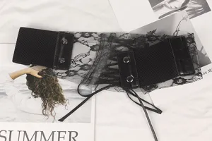 Close-up showing the delicate floral lace texture and snap buttons of the black corset belt