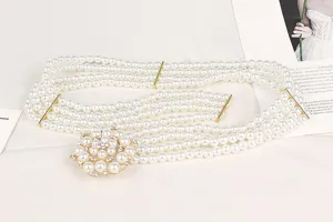 Macro view showing the elegant four-strand white pearls and rhinestone flower buckle