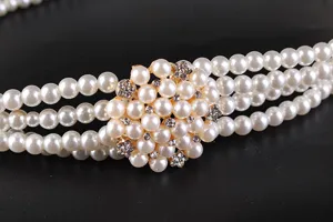 Macro view of elegant four-row pearl belt with sparkling rhinestone flower buckle