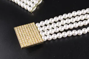 Macro view of elegant four-row elastic pearl belt with a sparkling rhinestone-encrusted buckle