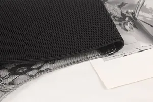 Macro detail of black wide elastic waist belt with floral lace and fine textured fabric