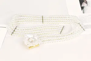 Detailed view of elegant four-strand pearl elastic belt with rhinestone flower buckle