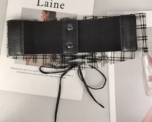 Detail view of transparent plaid corset belt with elastic black band and lace-up strings