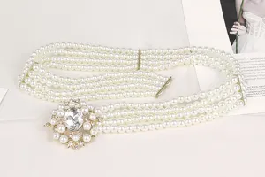 Detailed view of an elegant four-row pearl belt with a sparkling rhinestone flower buckle.