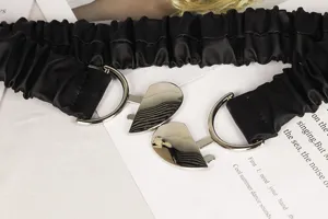 Detailansicht des schwarzen elastischen Taillengürtels mit glänzender silberner Herzschnalle