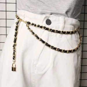 Detail shot of a stylish double-layer gold metal chain belt with black leather and padlock.