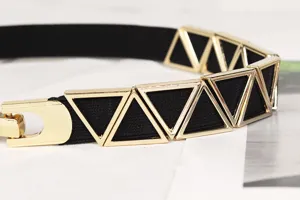 Close-up of vintage elastic waist belt with gold triangle metal decorations and U-shaped buckle