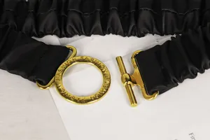 Nahaufnahme eines schwarzen elastischen Taillengürtels mit goldener Modeschließe.
