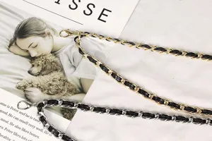 Close-up of gold and silver metal waist chains with woven black leather straps