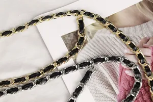 Close-up of elegant double-layer gold and silver metal chain belts with leather weave