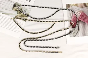 Détail de chaînes de taille en métal double couche avec cuir tressé noir en or et argent.