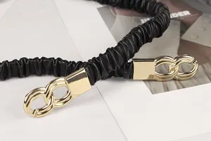 Nahaufnahme eines schwarzen, gerüschten elastischen Gürtels mit goldener Schnalle