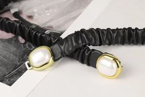 Detailansicht eines schwarzen elastischen Taillengürtels mit Perlengoldschnalle