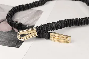Nahaufnahme von elegantem schwarzem elastischem Gürtel mit goldener Schnalle